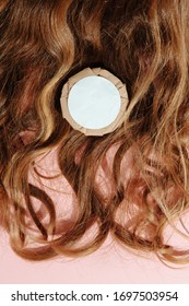 Hair Mask In A Plastic Container On The Curly Brown Hair Background. Organic Haircare Product.