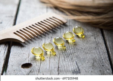 Hair Nourishment. Vitamin Serum Capsule On Wooden Background.