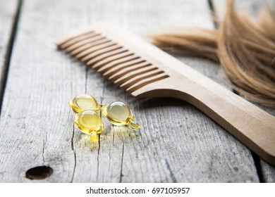 Hair Nourishment. Vitamin Serum Capsule On Wooden Background.