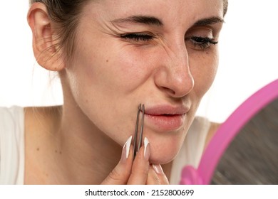 hair over the upper lip in women. girl with tweezers plucks a mustache. female antennae. problem skin.