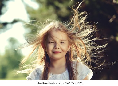Hair of pretty little girl hair is blowing in the wind 