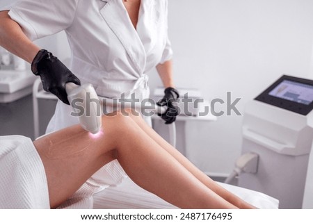 Hair removal procedure. Cropped shot of young fit woman client receiving laser hair removal procedure on body in beauty clinic. Women beauty and cosmetology concept