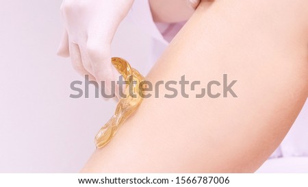 Hair removal at spa luxury studio. Woman legs wax with shugaring. Hot sugar.