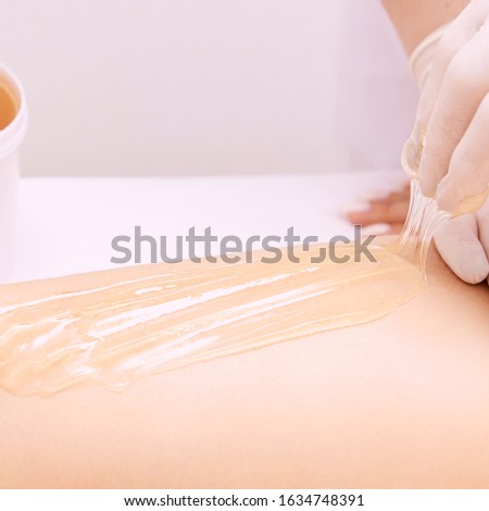 Hair removal at spa luxury studio. Woman legs wax with shugaring. Hot sugar.