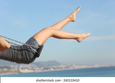 Hair Removed Woman Legs Swinging On The Beach With The Sky In The Background