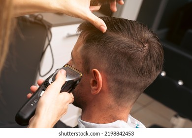 Hair salon master trimmed client hair with electric razor at barber shop. Male client getting haircut by hairdresser. Hair care, beauty industry, barber concept. - Shutterstock ID 2198842453