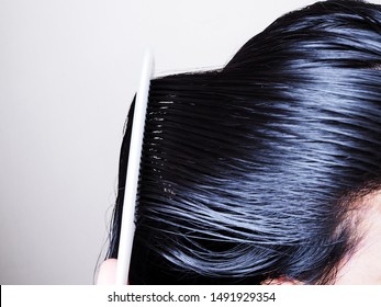 Hair And Scalp Health Care By Combing Black Hair And Long On Head With White Comb.