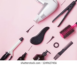 Hair styling and care items and products on pink background, top view. Beauty flat lay