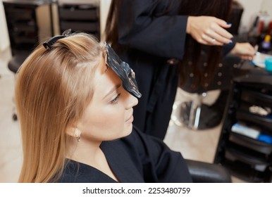 Hair stylist makes bouffant using comb on thin strands. Shatush technique for hair lightening - Shutterstock ID 2253480759