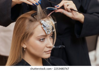Hair stylist makes bouffant using comb on thin strands. Shatush technique for hair lightening - Shutterstock ID 2253480767