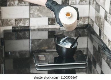 Hair stylist pouring an oxidant cream into the bowl preparing a coloring dye - Shutterstock ID 1100533667
