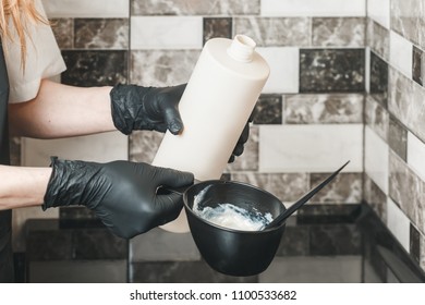 Hair stylist pouring an oxidant cream into the bowl preparing a coloring dye - Shutterstock ID 1100533682