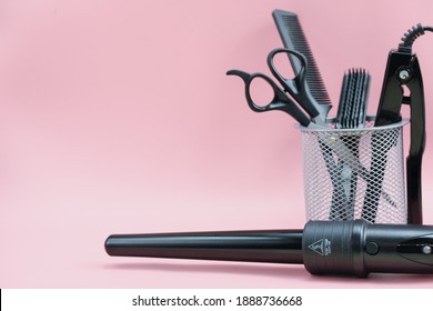 Hair Stylist Tools In A Basket. Scissors, Brush, Comb, Curling Iron. Pink Background. Home Hair Care. Beauty Salon Tools. Hairdresser's Equipment. Copy Space