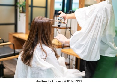 Hair Stylist Using A Hair Iron