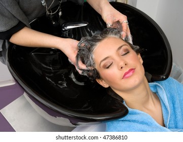 hair stylist washing woman hair with shampoo - Shutterstock ID 47386810