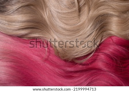 A hair texture of two hair colours: honey blond and rose pink closeups, a wavy shiny texture
