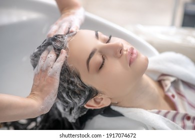 Hair wash. Hairdresser wahsing her customers hair with shampoo - Powered by Shutterstock