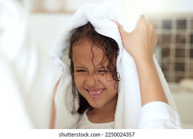 Haircare routine, cleaning and hair being washed by a mother for her happy, carefree and smiling daughter at home. Loving, caring and kind parent helping her child get dressed, get dry or get clean - Powered by Shutterstock