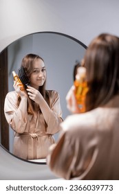 Haircare. Young Female Applying Hair Spray While Standing Near Mirror - Shutterstock ID 2366039773