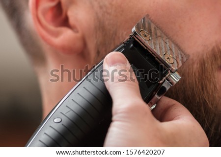haircut beard typewriter. beard trimmer. Barber services. The man in the barbershop. Hipster
