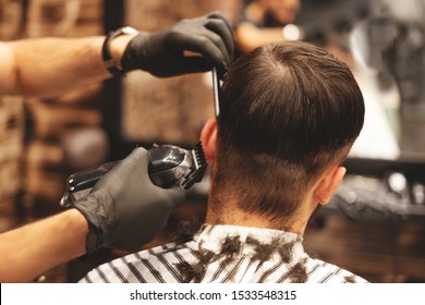 Haircut head in barbershop. Barber cuts the hair on the head of the client. The process of creating hairstyles for men. Barber shop. Selective focus