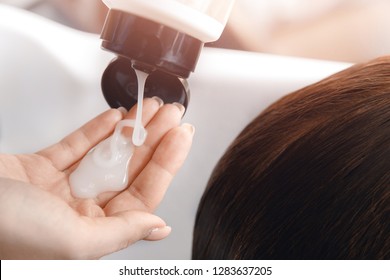 Hairdresser applies shampoo and hair conditioner client head. Concept spa beauty salon.