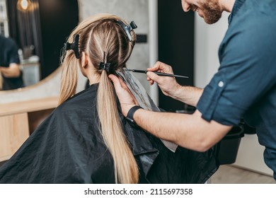 Hairdresser Is Applying Bleaching Powder On Woman's Hair And Wrapping Into The Foil. 