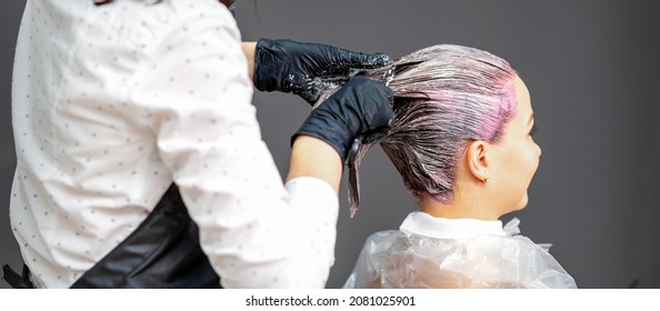 A hairdresser is applying color to the hair of a customer. Hair coloring in a beauty salon. Beauty and people concept. Close-up back view - Powered by Shutterstock