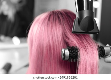 Hairdresser blow drying client's pink hair in salon, closeup - Powered by Shutterstock