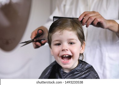 Hairdresser and boy. The boy is doing his hair. Cut child in the hairdresser.