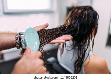 Hairdresser brushing wet long customers hair before haircut. Close-up. - Shutterstock ID 1143836231