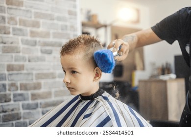 Hairdresser cleaning boy's head at barber shop after styling his hair. - Powered by Shutterstock