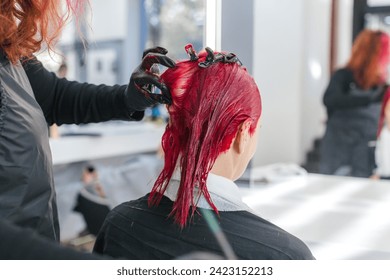 hairdresser colorist dyes a client's hair red in a hair salon close up, anonymous - Powered by Shutterstock