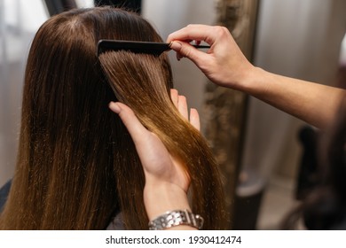 The hairdresser is combing the hair of the client. Close-up of hands with a comb and client's hair. - Powered by Shutterstock