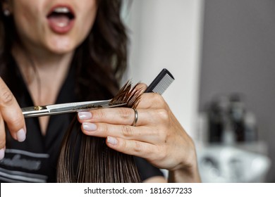 The Hairdresser Cuts Off A Strand Of Hair To The Client And Is Horrified. Open Mouth In Exclamation. Hairdresser Mistake.