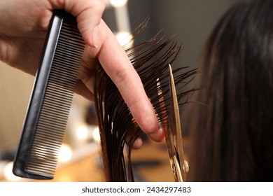 Hairdresser cutting client's hair with scissors in salon, closeup - Powered by Shutterstock