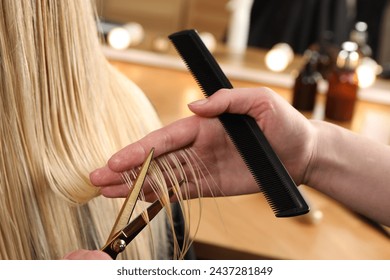 Hairdresser cutting client's hair with scissors in salon, closeup - Powered by Shutterstock