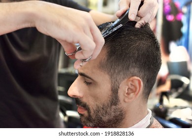 A hairdresser cutting man's hair