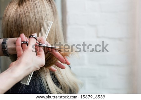 Hairdresser doing haircut. Professional hairdresser scissors, brush on workplace. Professional Hairdresser tools, equipment. Hairdresser service. Beauty salon service. Close up with space for text.