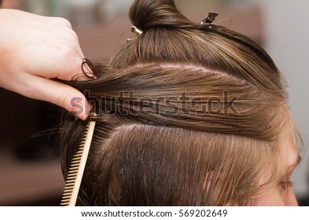 hairdresser drying female client's wet hair in salon
