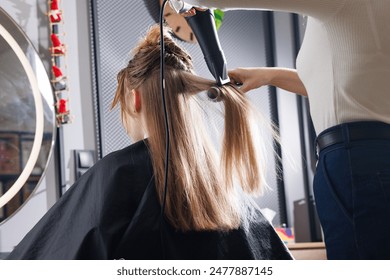 hairdresser drying hair with hair dryer and comb in beauty salon, drying hair close up, self care concept - Powered by Shutterstock