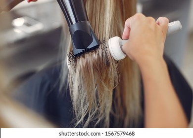 Hairdresser drying head her client. Woman in a hair salon - Powered by Shutterstock