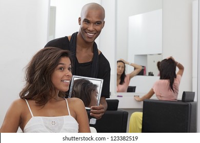 Hairdresser holding a mirror behind young woman - Powered by Shutterstock