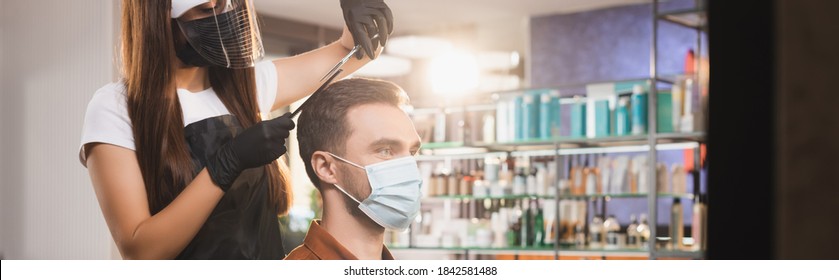 hairdresser in latex gloves and face shield cutting hair of man in medical mask, banner - Powered by Shutterstock