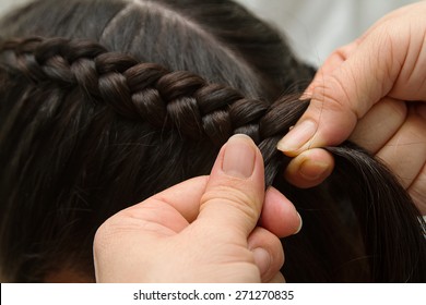 Hairdresser make braids in beauty salon