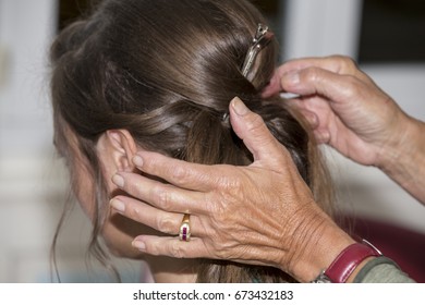 Hairdresser makes upper bun chignon wedding hairstyle close-up