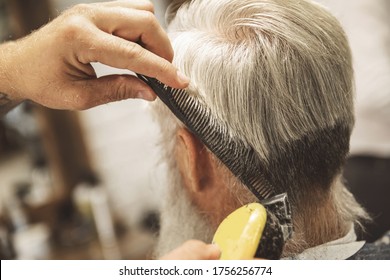 Hairdresser Making Stylish Haircut For  Old Man In The Barbershop