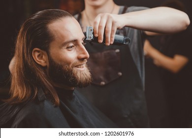 Hairdresser for men barber shop. Process of grooming long hair. - Powered by Shutterstock