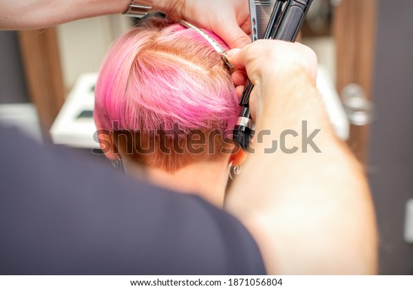 Hairdresser pinches hair with the clip before doing
hairstyle in a hair
salon