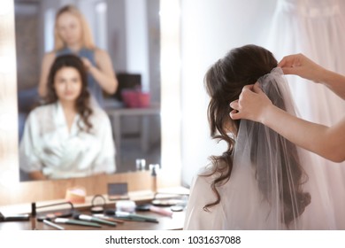 Hairdresser preparing bride before her wedding in room - Powered by Shutterstock